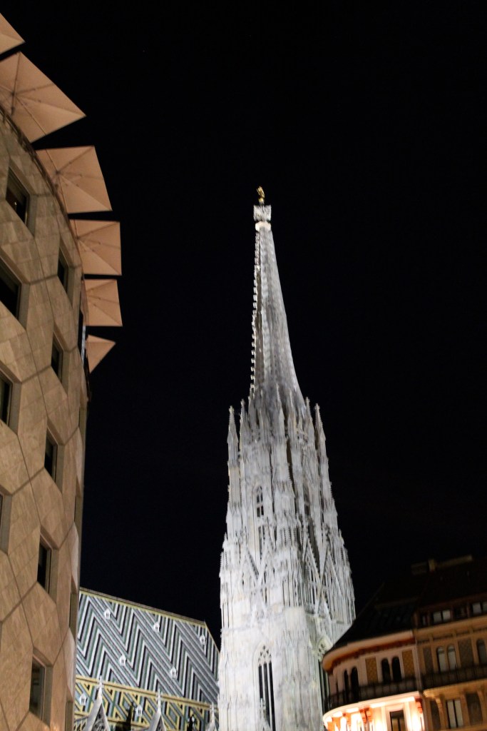 Juxtaposition of the modern building, on the left, with the old cathedral spire, at night!